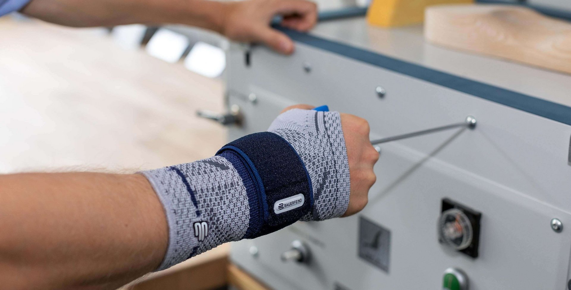Bildausschnitt eines Handwerkers, der bei der Arbeit zur Unterstützung seines Handgelenks eine ManuTrain Bandage trägt. Diese bietet Entlastung bei Handgelenksarthrose.